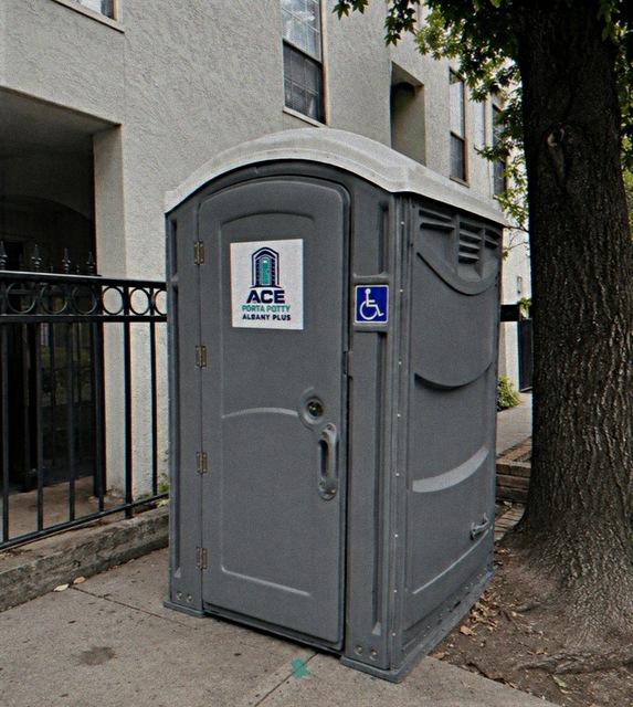 ADA accessible wheelchair porta potty rental unit on a city sidewalk