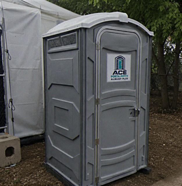 Event porta potty rental unit placed beside a catering tent