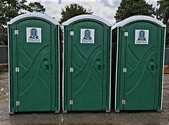Clean standard porta potty rental units lined up in the service yard